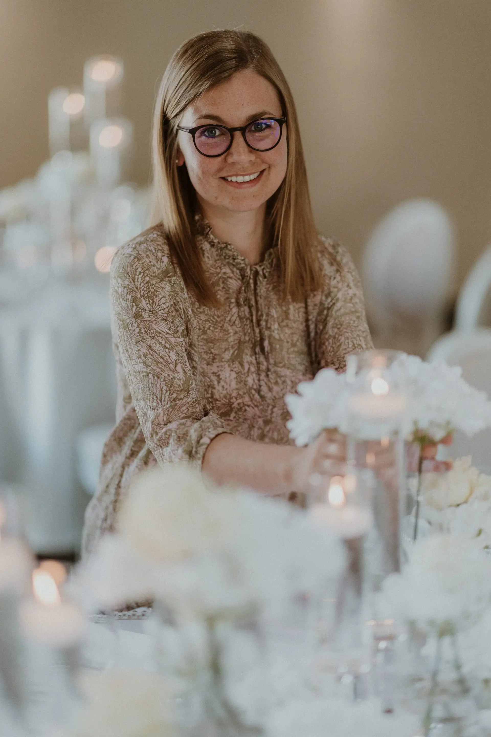 Portrait von Eva Schrödel an einem in weiß gedeckten Hochzeitstisch