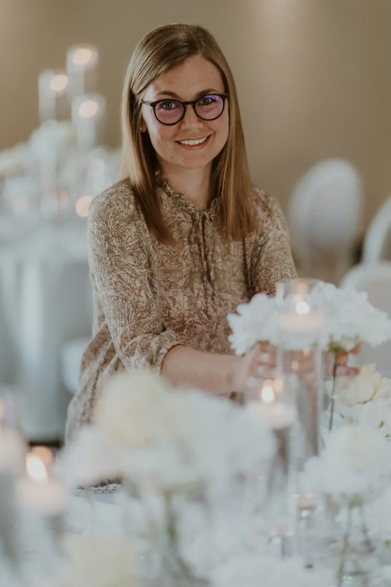 Portrait von Eva Schrödel an einem in weiß gedeckten Hochzeitstisch